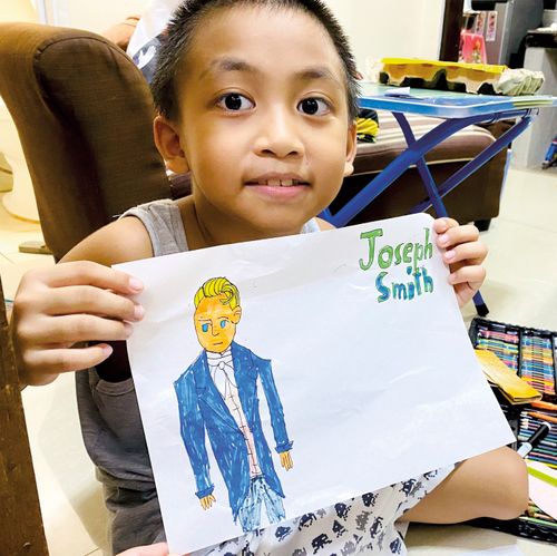 girl holding drawing of Joseph Smith