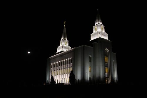 The Kansas City Missouri Temple after dark, glowing with the lights on the spires and within the windows.
