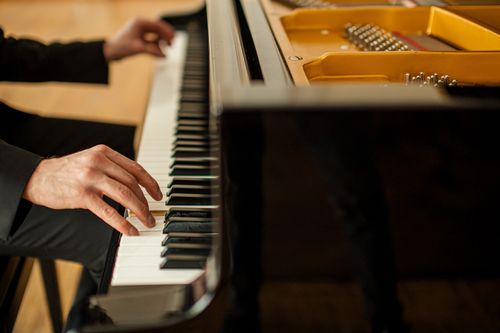 close-up of person playing piano
