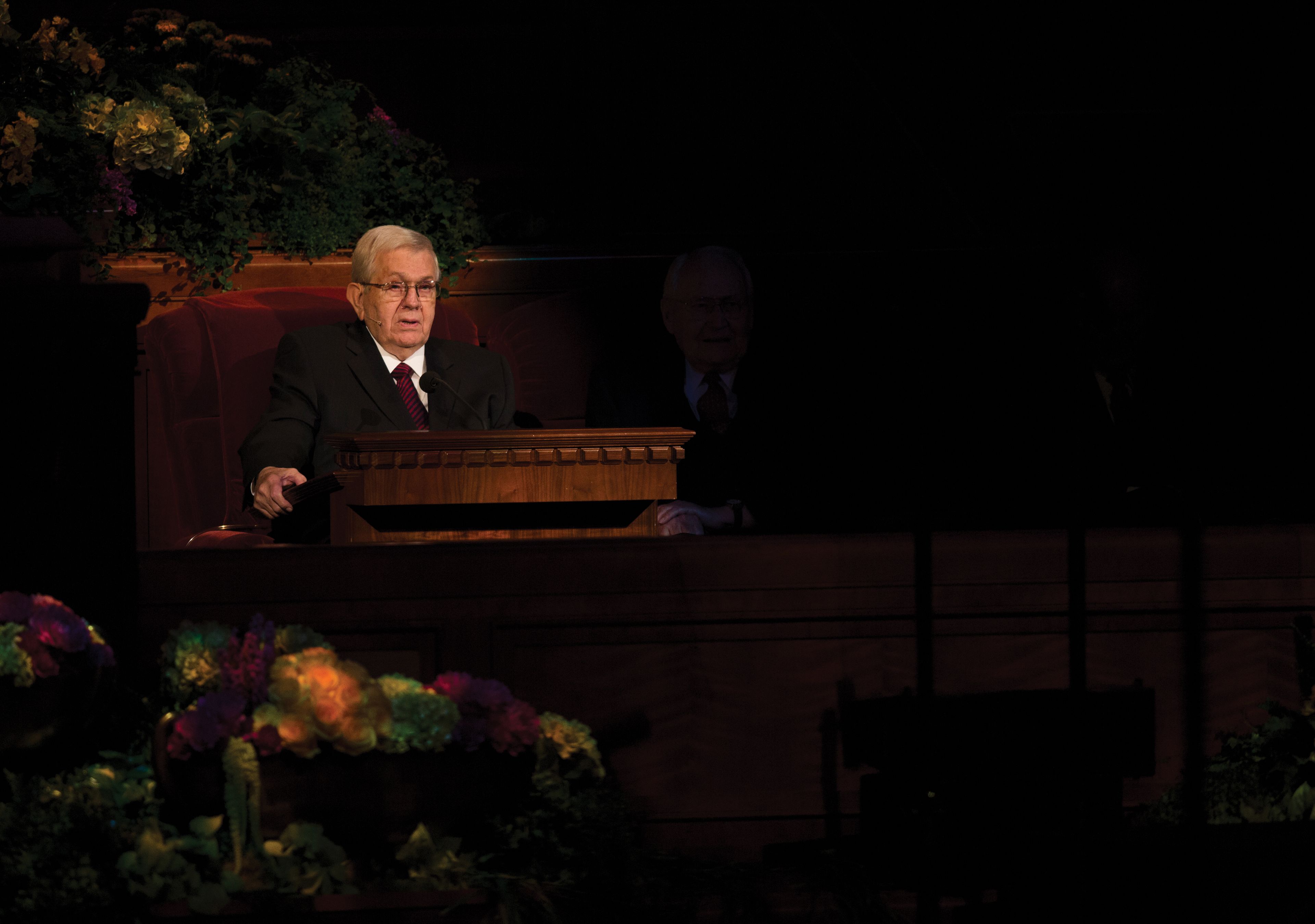 Boyd K. Packer sitting and speaking to the congregation at general conference.