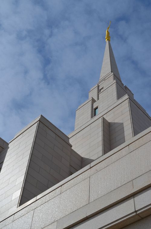 A view of the spire on the Oquirrh Mountain Utah Temple, looking toward the angel Moroni statue and the blue sky beyond.