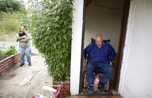 Wilson at the doorway while his daughter walks outside holding dogs