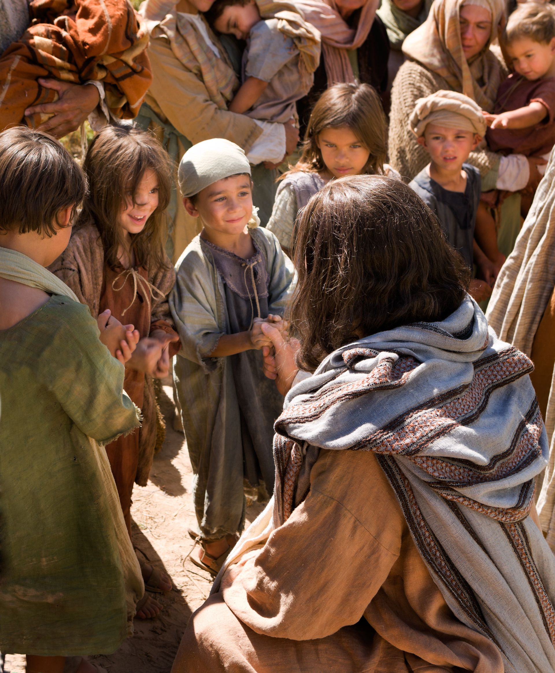 Jesus Christ, surrounded by a group of children, shows them love and compassion.