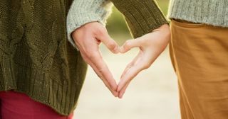 a couple’s hands forming a heart