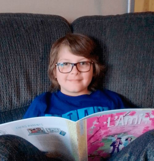 A young boy named Tom reads the Friend in his home.