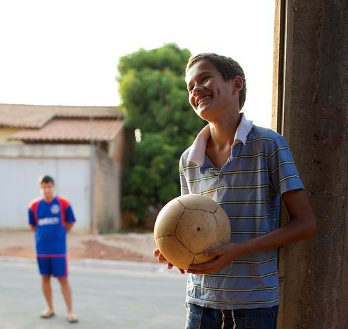 boy smiling holding ball