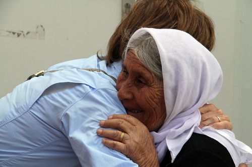 Aid worker embracing a refugee