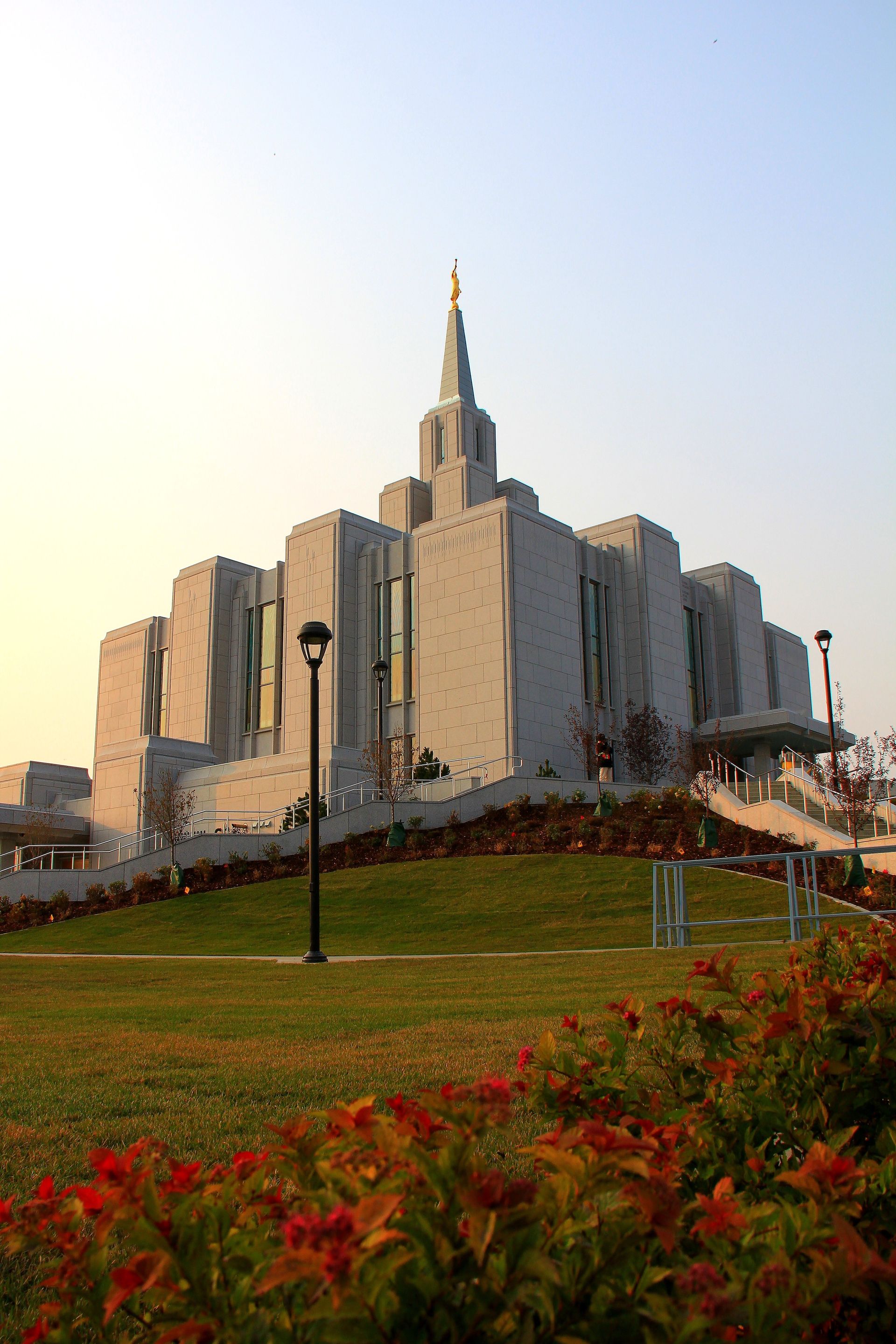 A portrait view of the Calgary Alberta Temple from the temple grounds during the evening.