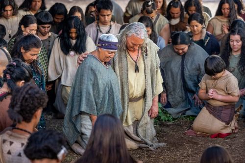 Nephi and Nephi's wife kneel down in prayer with their congregation.
