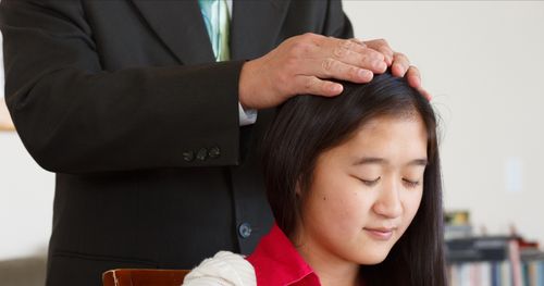 young woman receiving a blessing