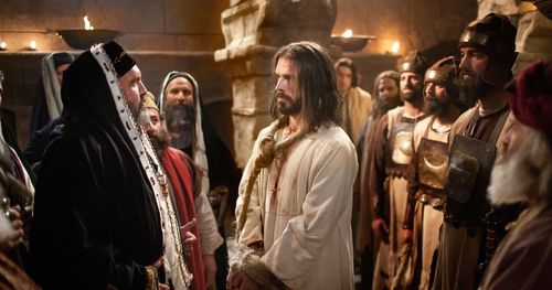 Jesus standing bound before Caiaphas and the Sanhedrin. Outtakes include the false witnesses next to Jesus, Caiaphas rending his clothing, Jesus with a rope around his neck and his clothing is blood stained, Caiaphas alone, a soldier bringing Jesus through a doorway and just the saviors bound hands.