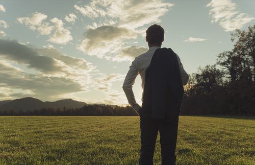young adult man looking across a field