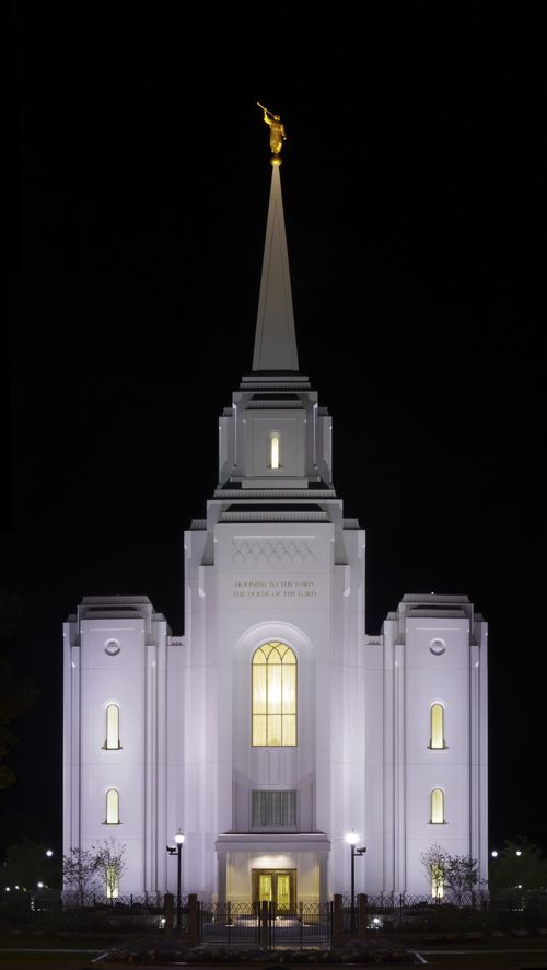 The front of the Brigham City Utah Temple lit up against a black night sky.