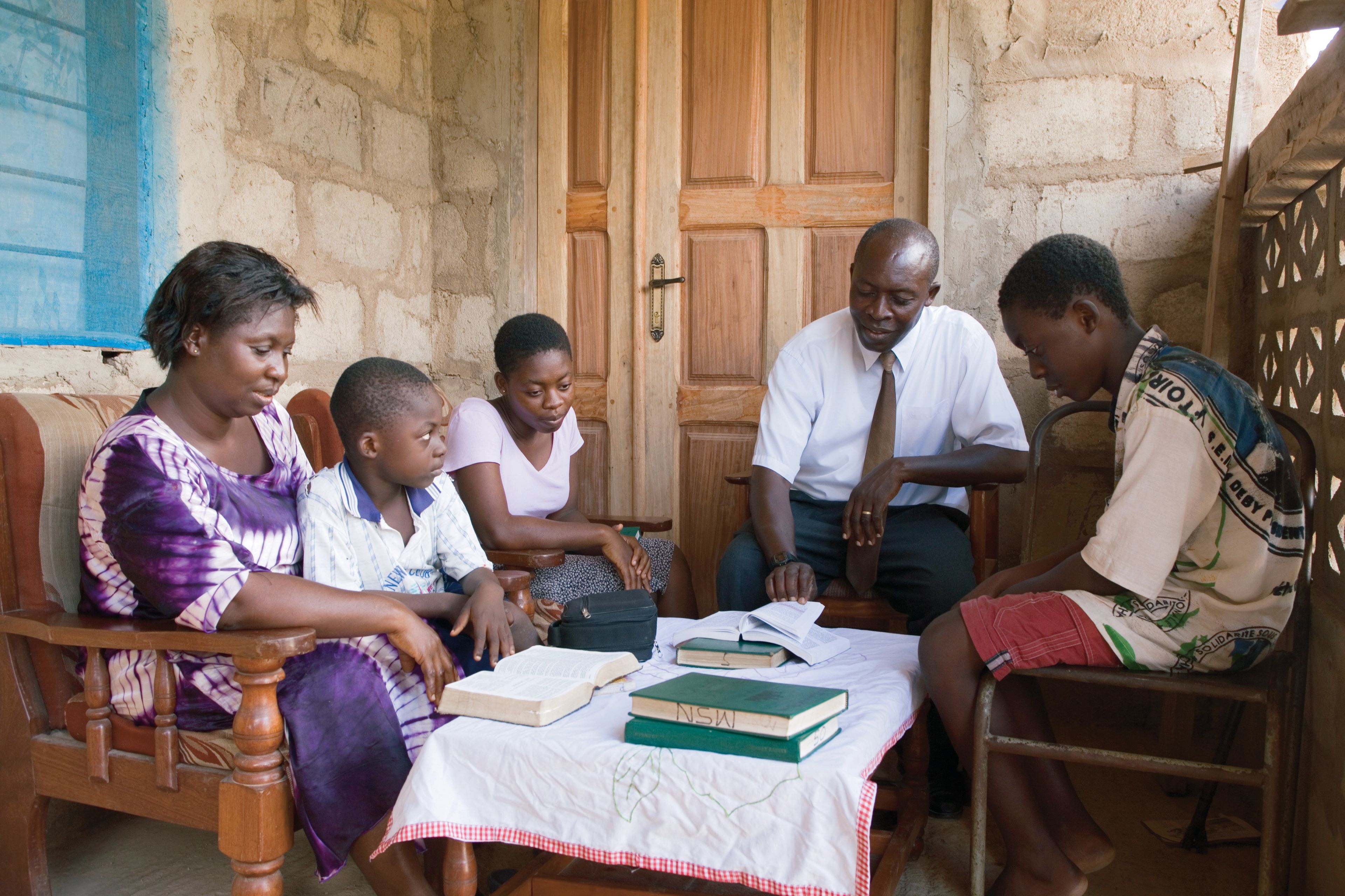A family in Ghana hold family home evening and read scriptures together.