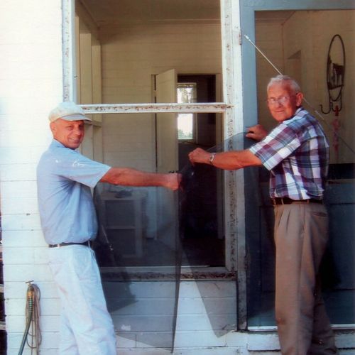 senior missionaries replacing a window