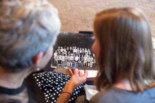 Grandmother and granddaughter looking at old family history photos together