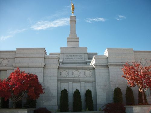 The Reno Nevada Temple, with a view of the inscription on the wall, "Holiness to the Lord: The House of the Lord," and with trees on either side changing colors in the fall.