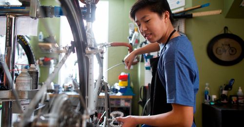 young man working on bicycles