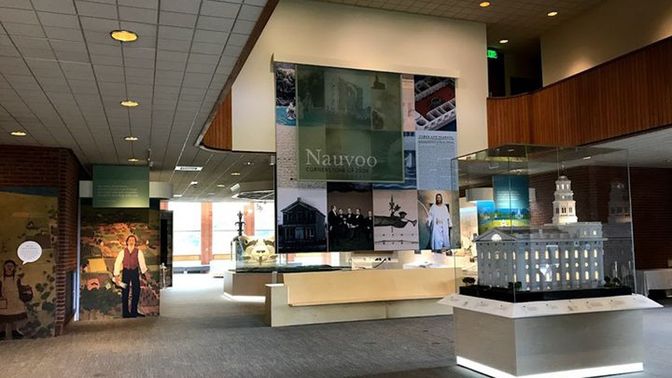 Museum with an exhibit title banner and scale model of the Nauvoo Illinois Temple. 