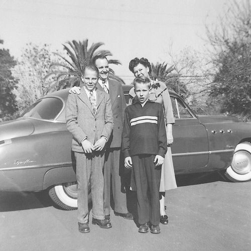 President Howard W. Hunter with his wife and two young sons, standing in front of a car.