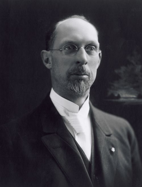 A portrait of the prophet George Albert Smith in oval glasses, a white shirt, and a black suit, dated December 20, 1919.