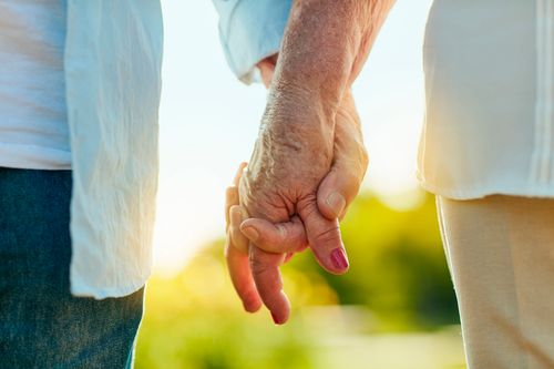 elderly couple holding hands