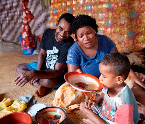 dad, mom, and son eating together