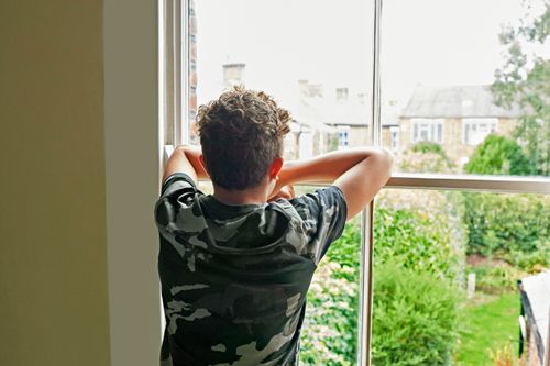 young man looking out the window