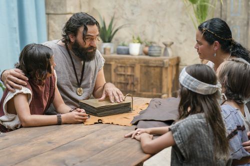 King Benjamin gathers with his family around a table in the Land of Zarahemla and tells them he can no longer be king. He shows his family the brass plates.