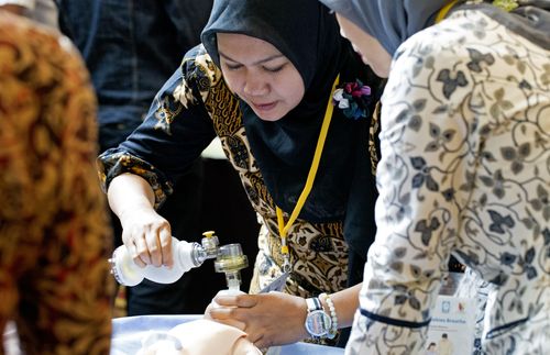 woman using neonatal resuscitation device