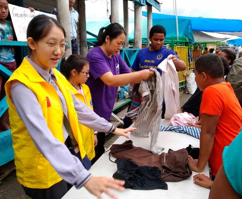 Alice and her family handing out clothes