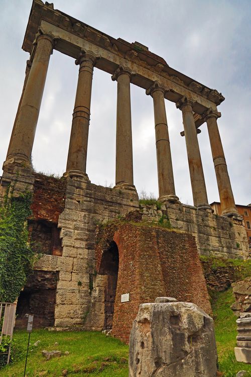 The six pillars of a forum with green vegetation below in Rome, Italy.