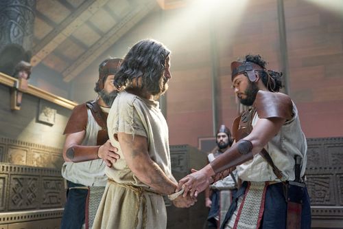 Abinadi is brought in to the court of King Noah by guards.