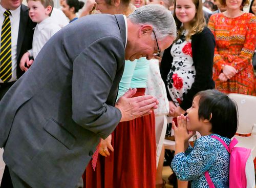 Elder Andersen bowing to young girl