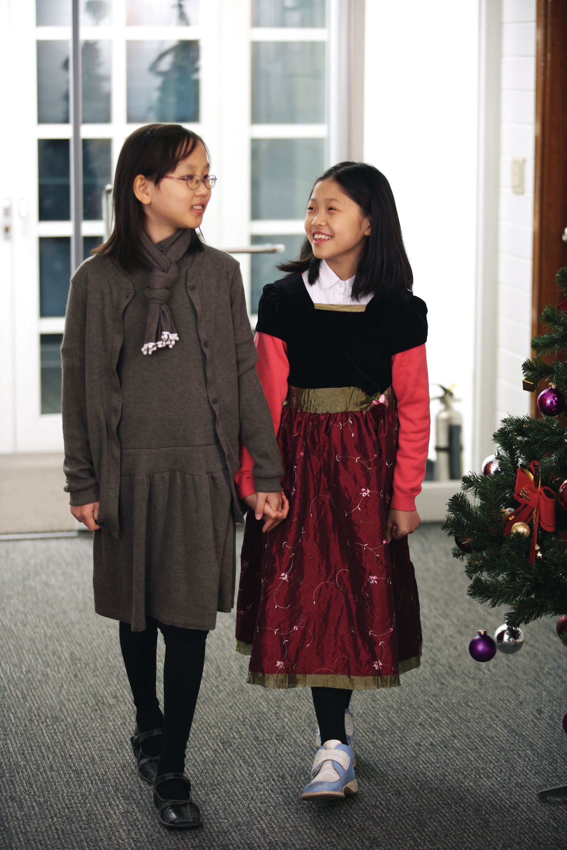 Two sisters in Christmas dresses attend church at Christmastime.