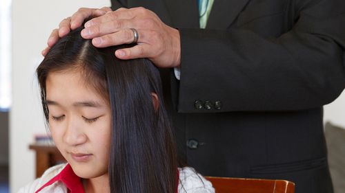 woman receiving a priesthood blessing