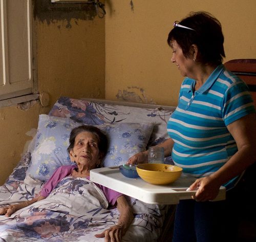 woman visiting a sick woman in bed