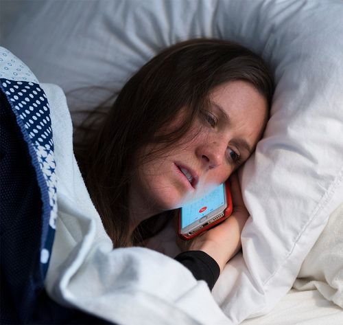 woman sick in bed on phone