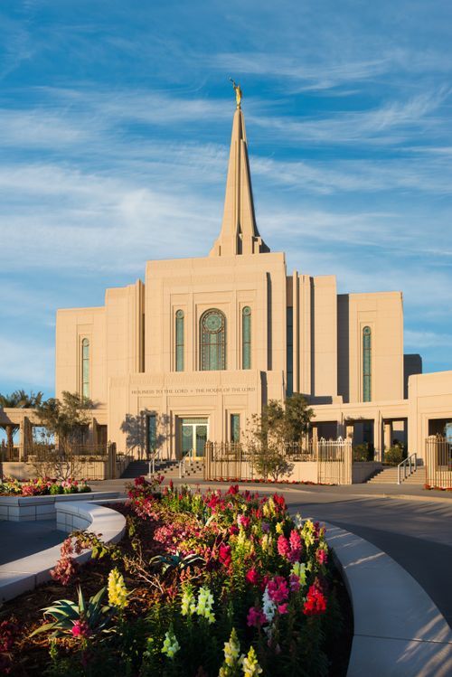 The front of the Gilbert Arizona Temple, with a flower bed in full bloom curving to the right.