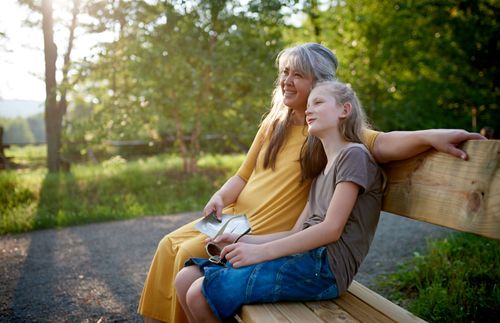 an older woman sitting on a bench with a young woman