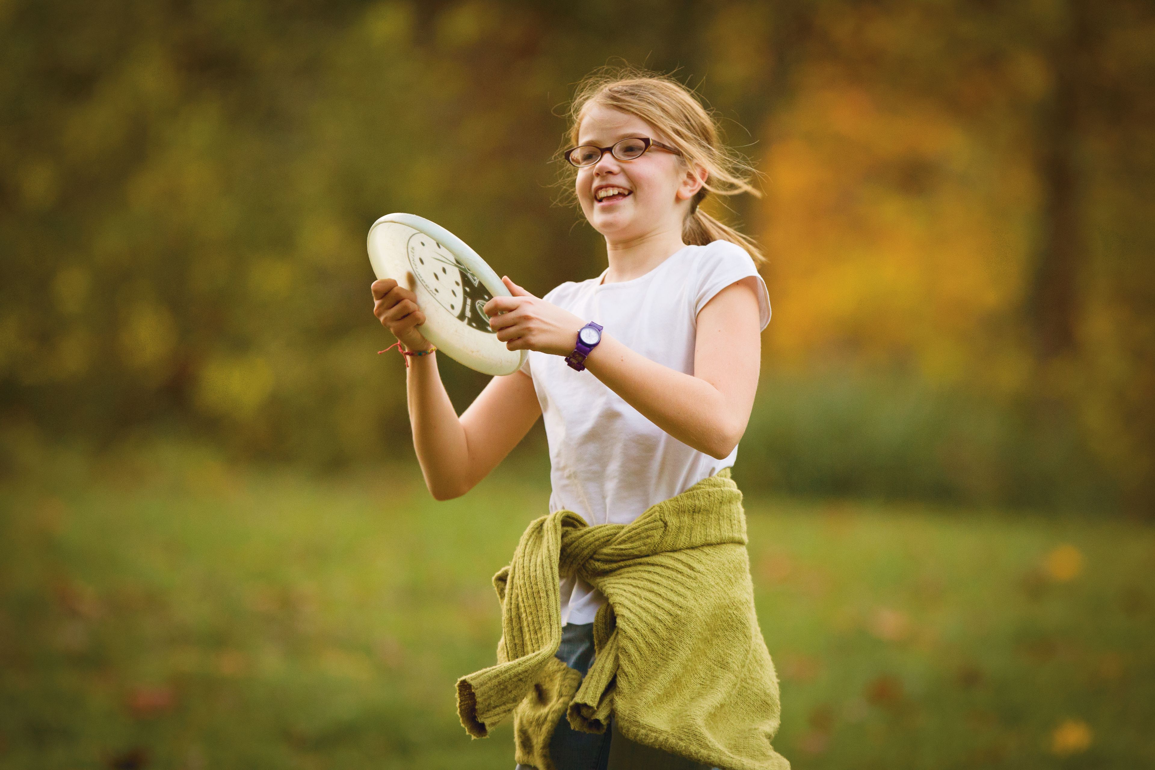 A young girl plays outside with a Frisbee.