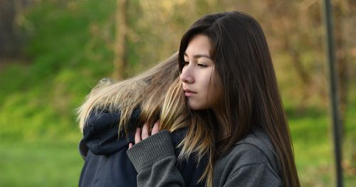 Young woman comforting another young woman