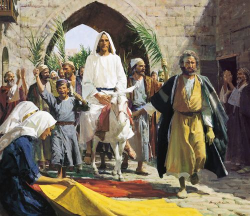 Jesus Christ in white robes riding on a white donkey. He is passing through a brick arch into Jerusalem. Numerous people are following Him. Some of which are waving palm leaves and laying cloth on the ground in front of Him.