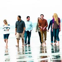 Young single adults walking on the beach.