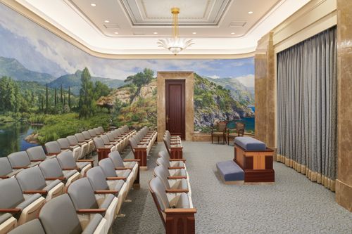 An instruction room in the Rome Italy Temple, with murals on the wall.
