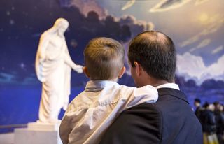 father and son looking at Christus statue