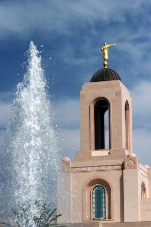 The spire on the Newport Beach California Temple, with the water from a fountain on the grounds showing on the left side.