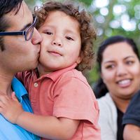 Young family in New Zealand.  The parents are holding their two boys.