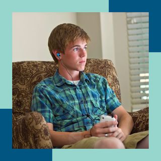 A young man wering earphones listening to music.