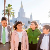 A family spends time together on the grounds in front of the Oakland Temple.